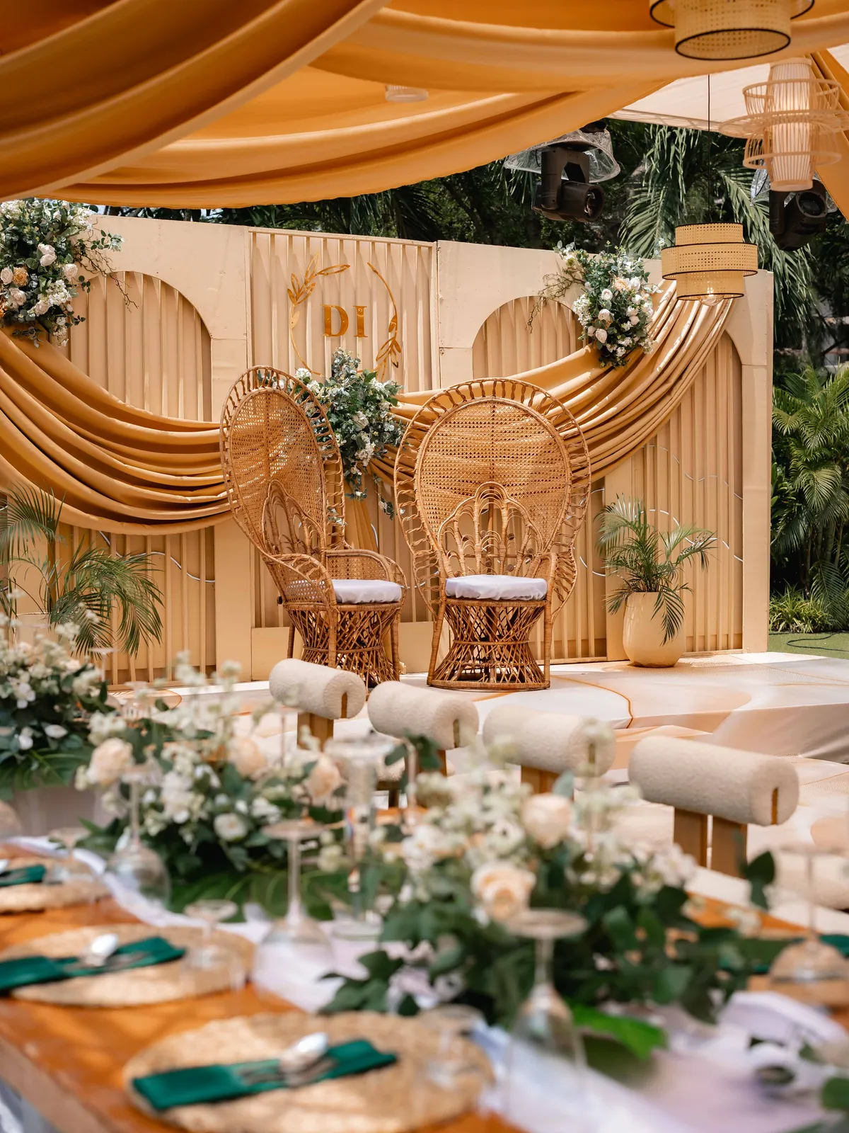 Floral centrepieces and emerald green napkins on a styled reception table