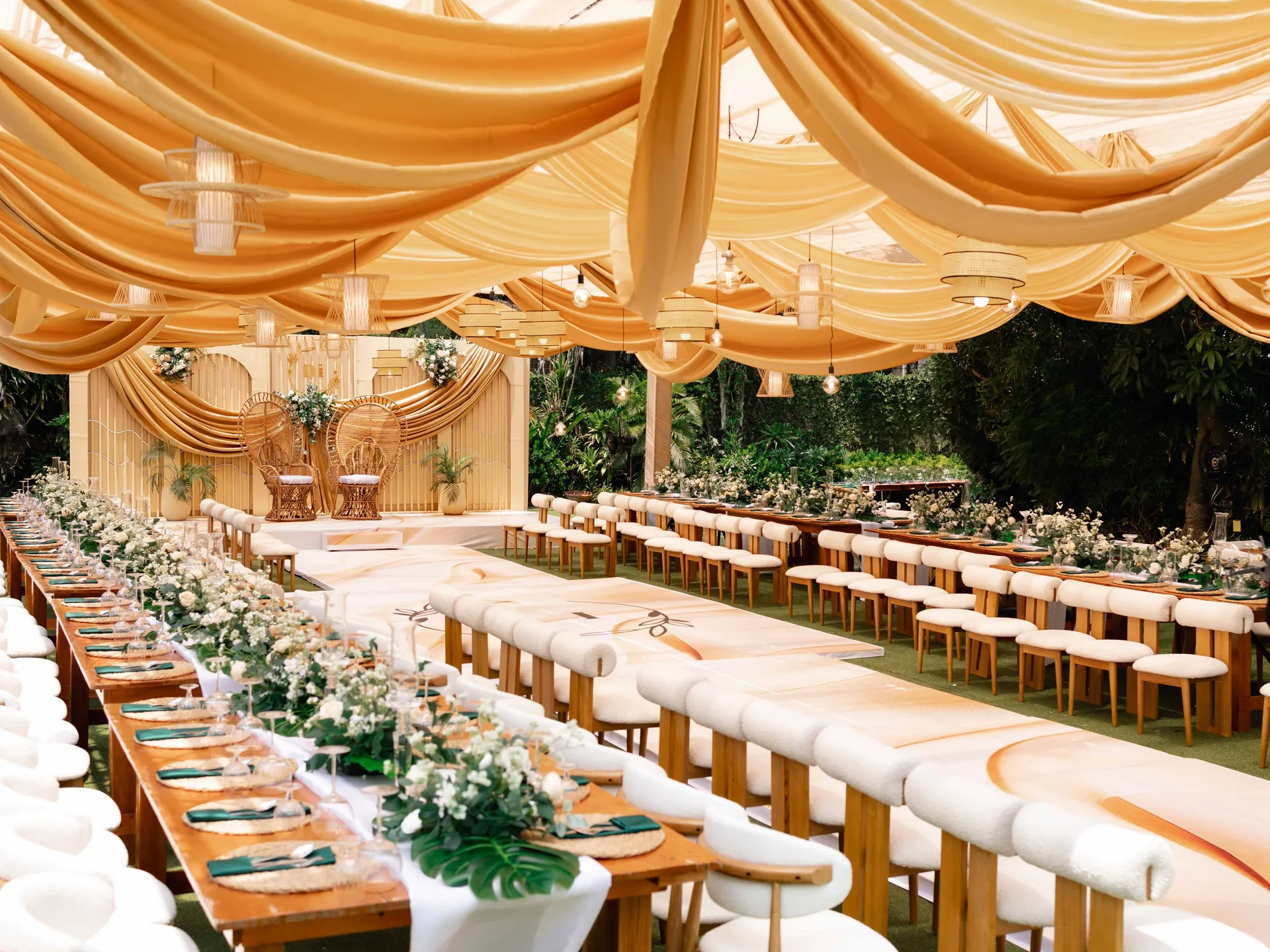 Garden wedding ceremony setup with cream and green decor
